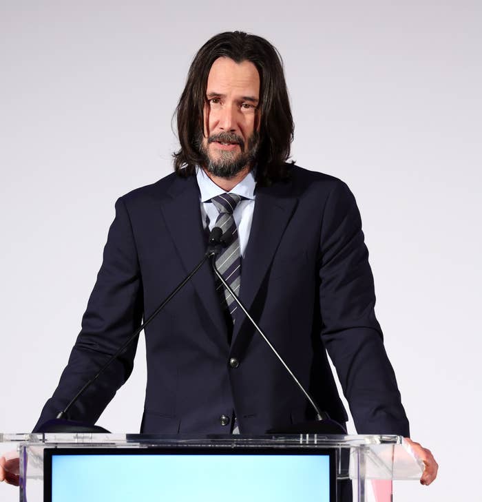 Keanu speaking at a podium