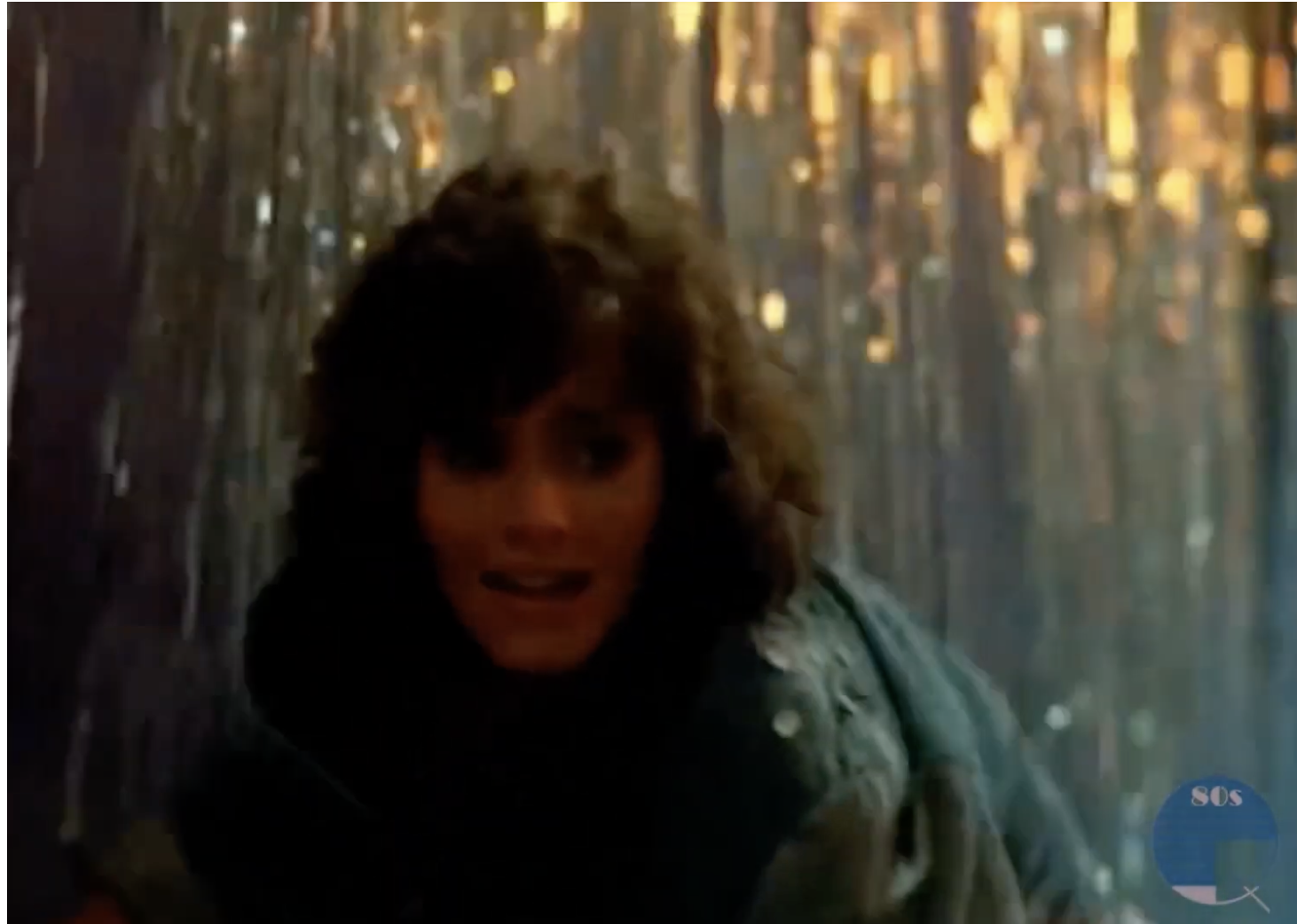 A screenshot of Courteney Cox running and looking scared in a denim jacket