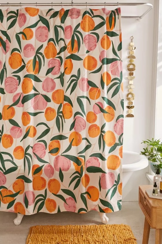 The peach shower curtain hung on the bath