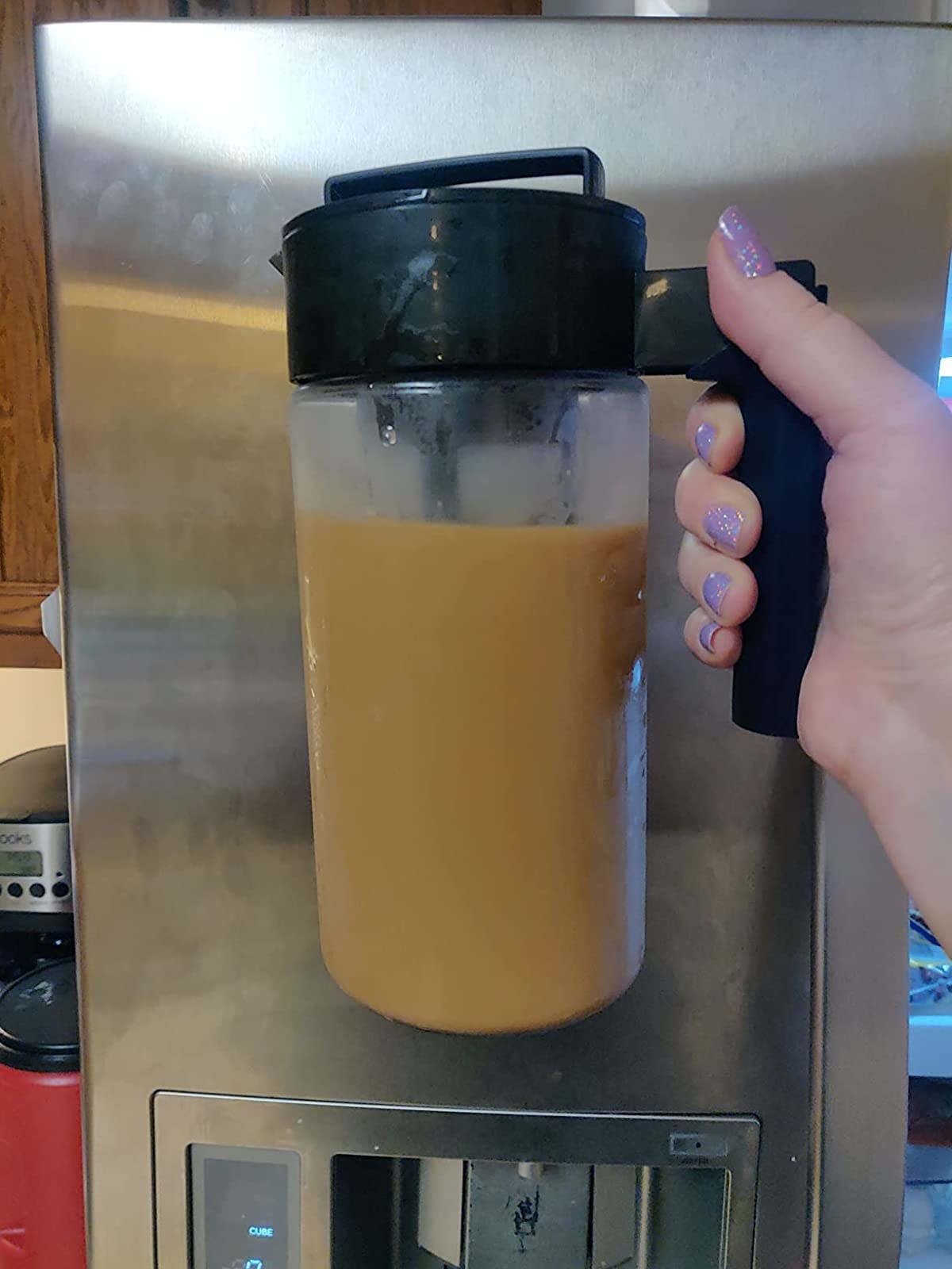 Reviewer holding pitcher of iced coffee