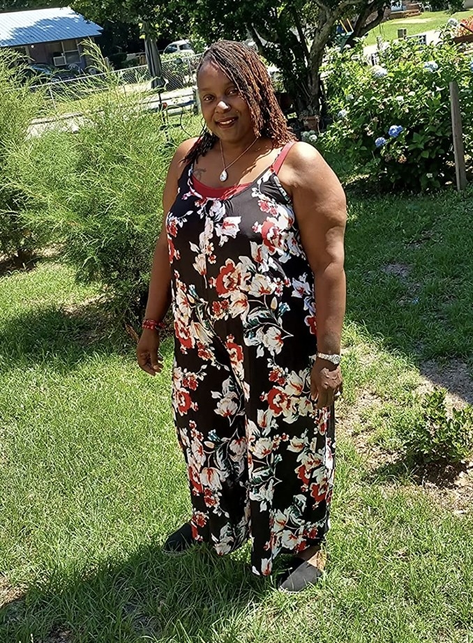 A reviewer wearing the romper in black with red and white floral details