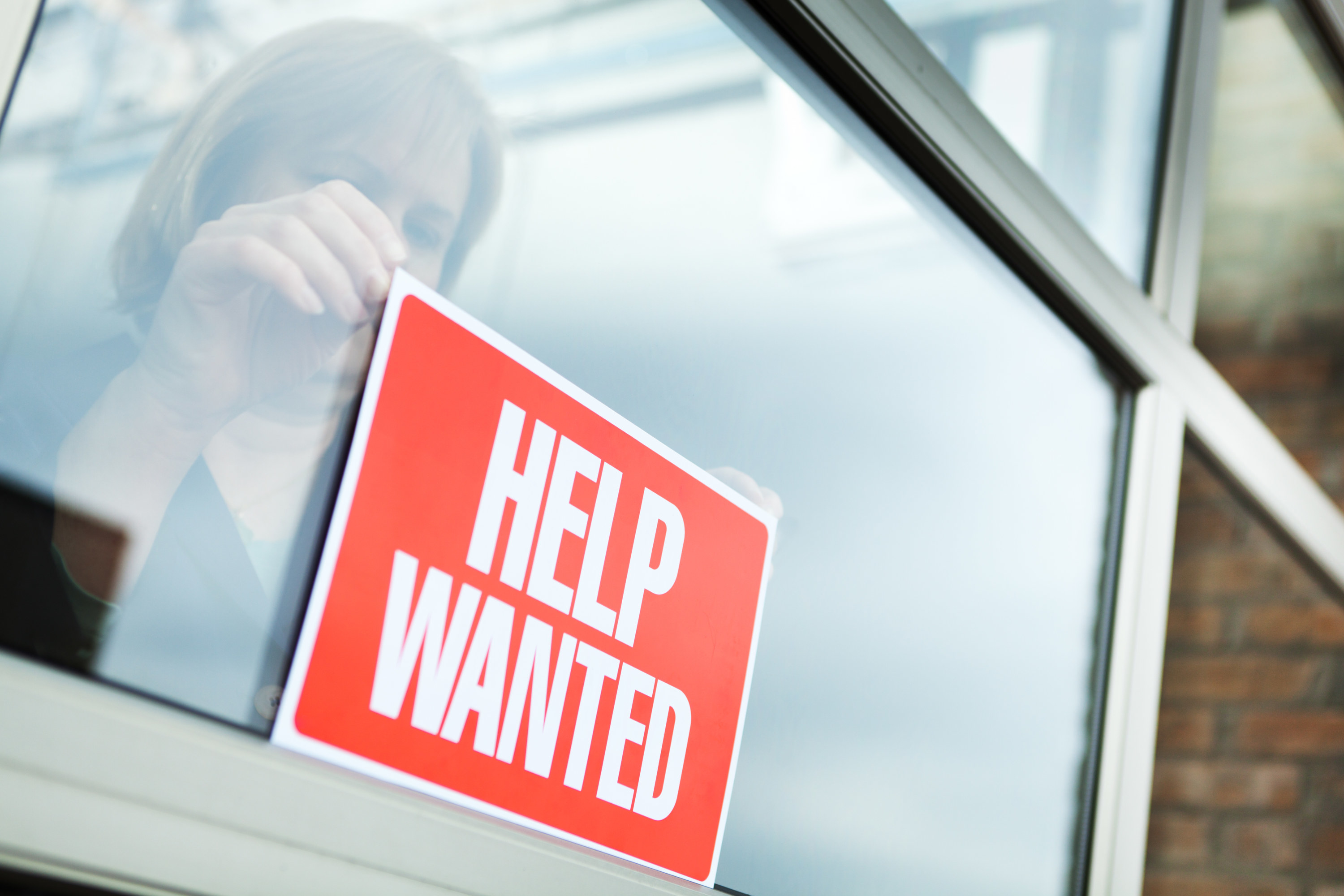 a help wanted sign in the window