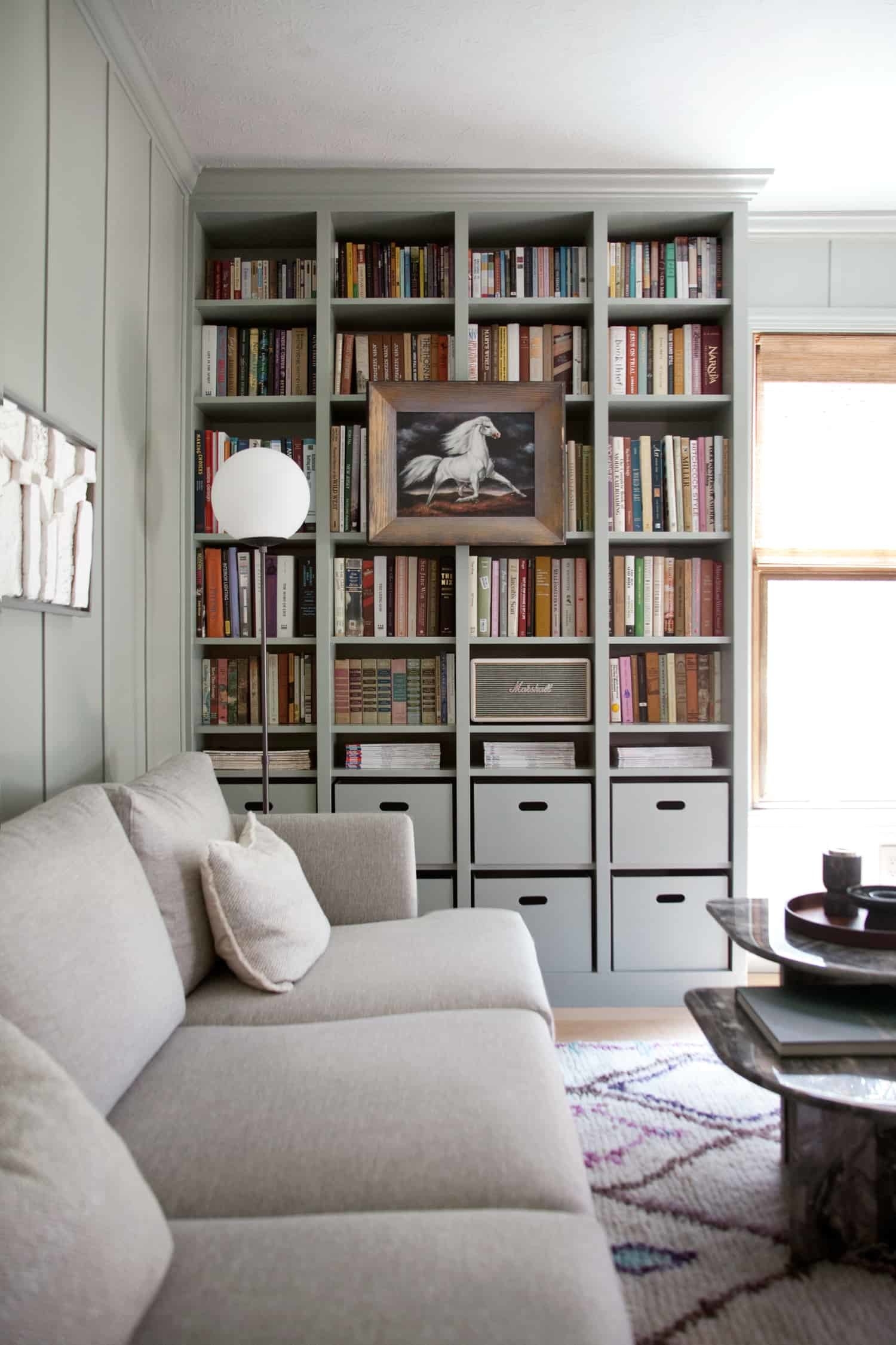 blogger&#x27;s living room with floor to ceiling grey built-in bookshelves