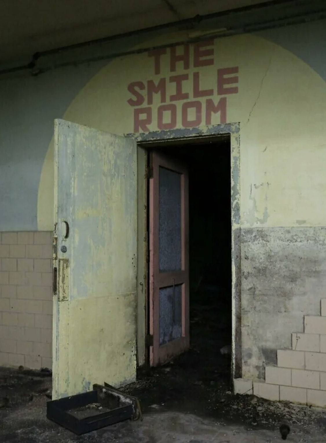 creepy abandoned building with a door open to the smile room