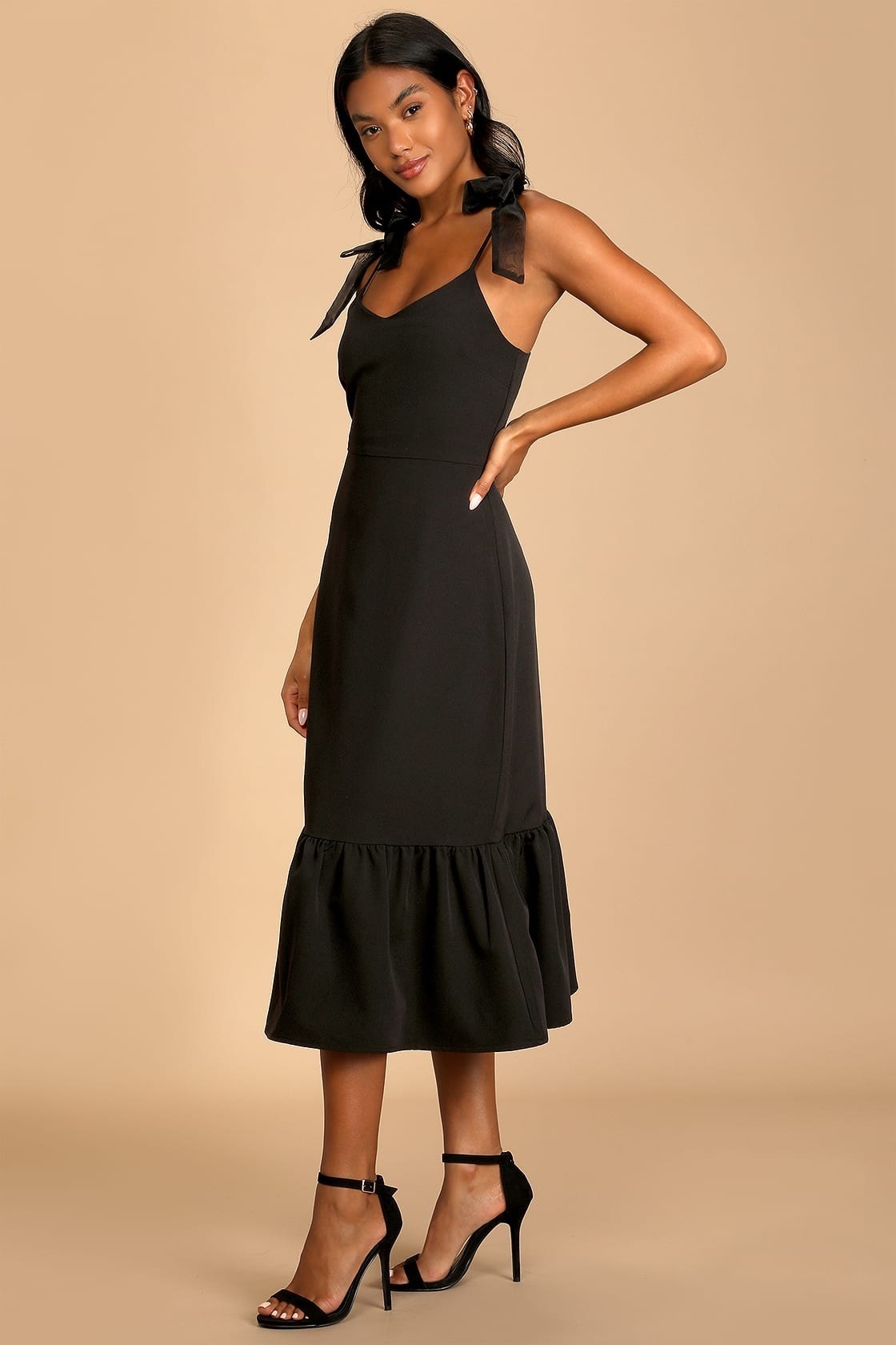model wearing black sleeveless midi LBD with black heeled sandals