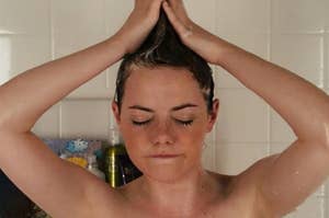 Emma Stone standing in the shower and forming her hair into a mohawk as Olive in Easy A