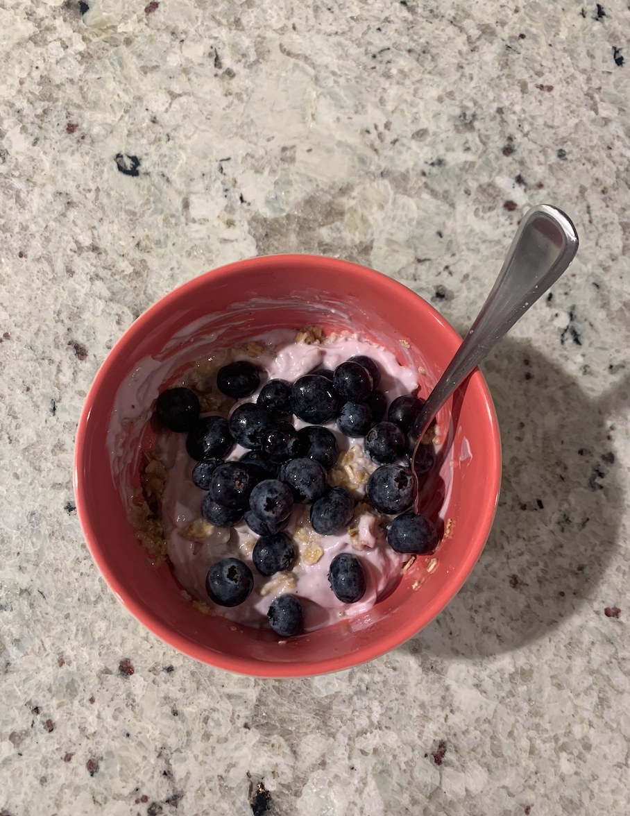 A bowl of oatmeal, yogurt, and blueberries