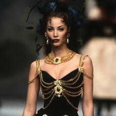 The 1992 dress on the runway. It is a simple black dress embellished with gold chains