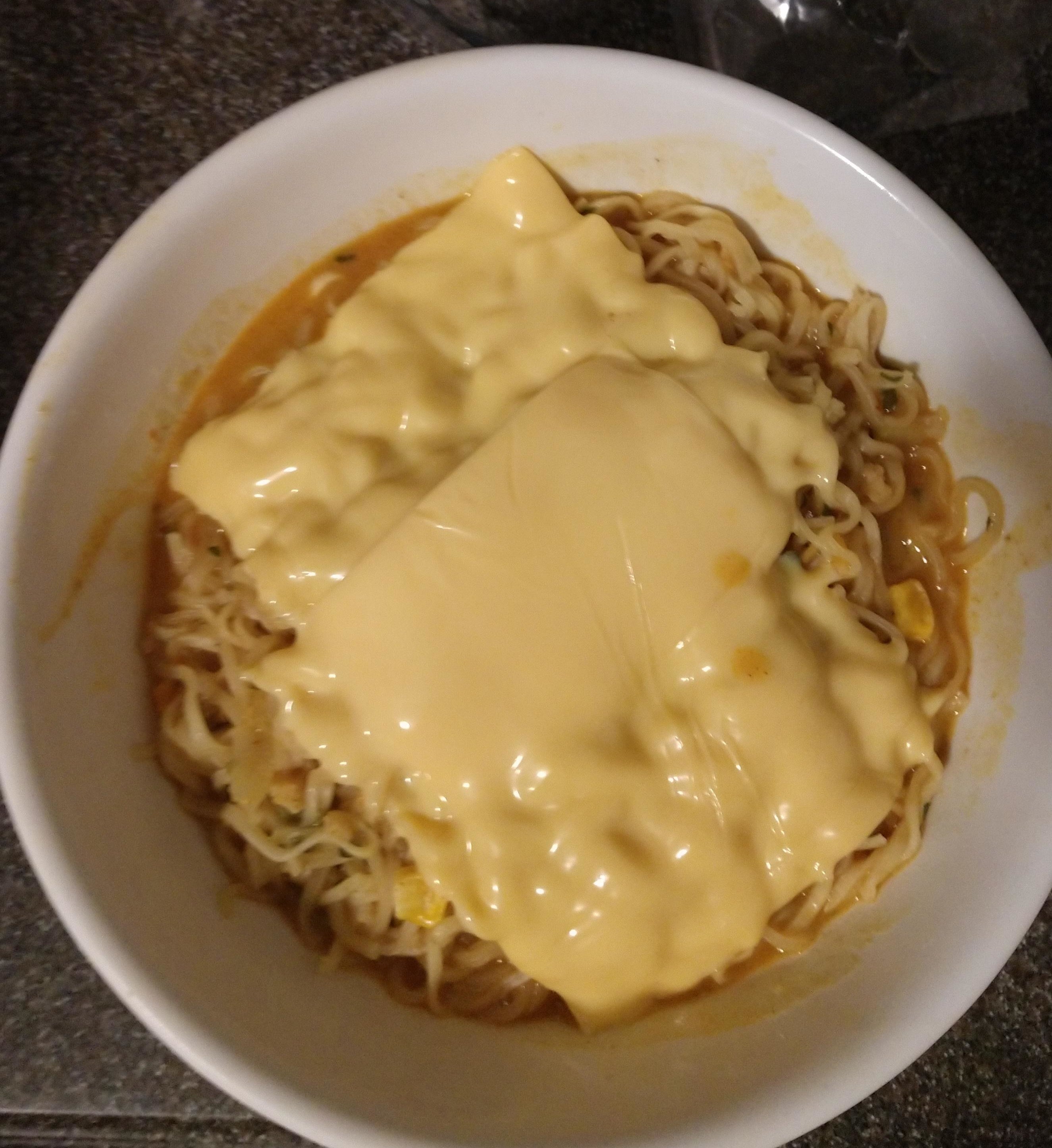 A bowl of ramen topped with melted cheese