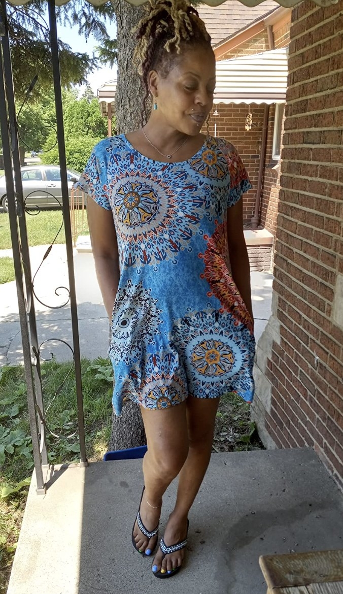 A reviewer wearing the dress with mandalas on it