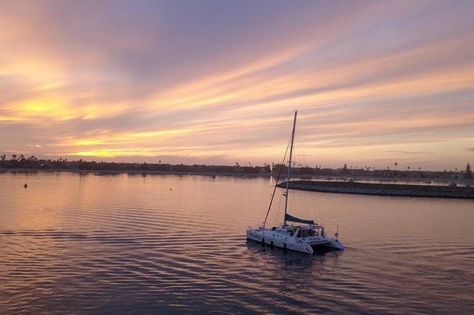 A catamaran sailing at sunset