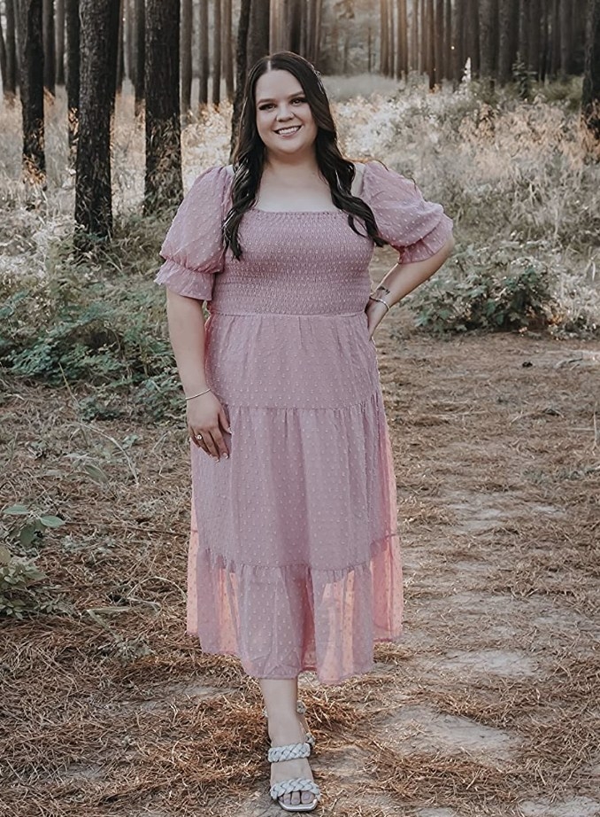 A reviewer wearing the dress in a light blush color