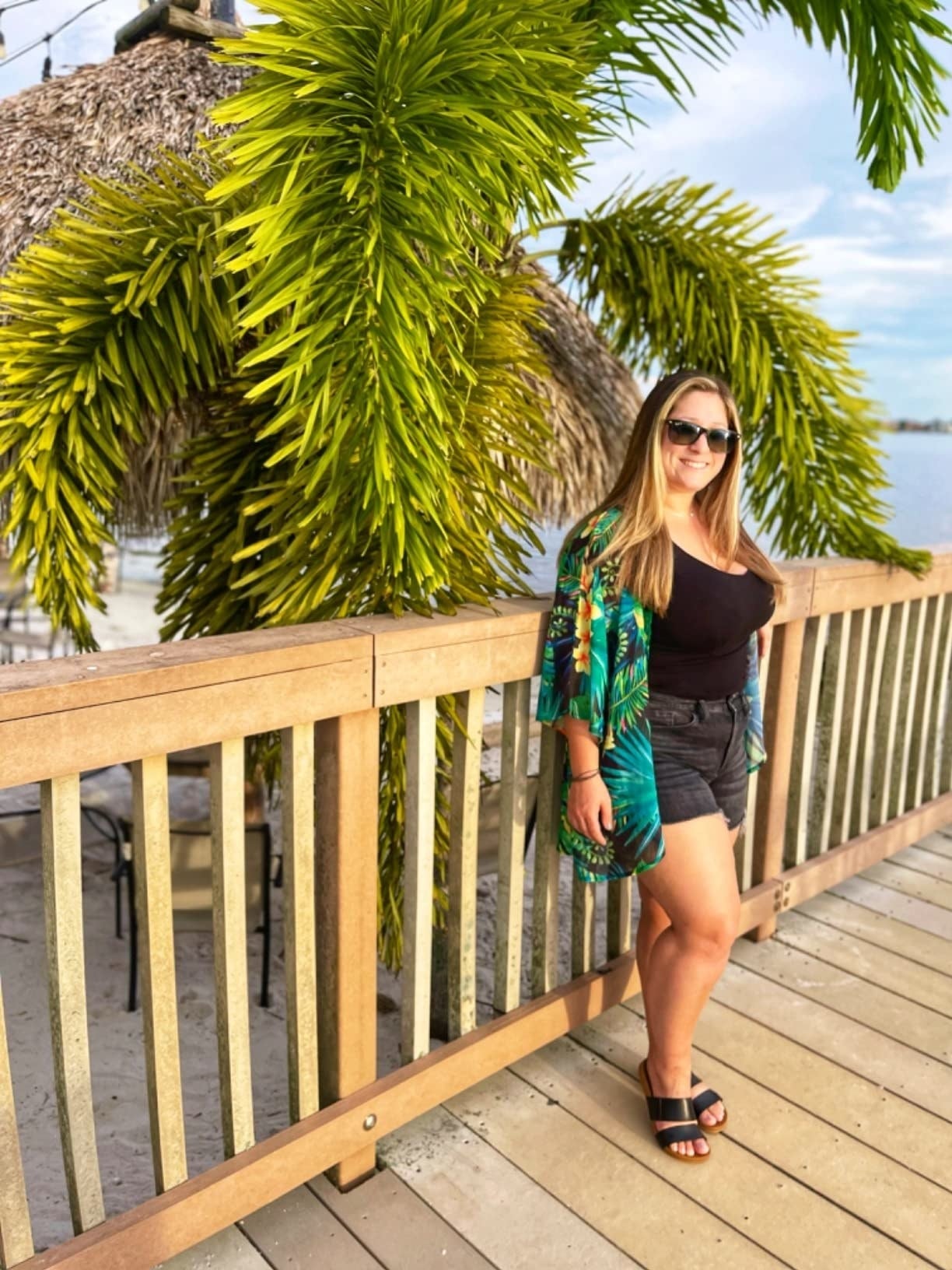 Reviewer posing against boardwalk successful  greenish  jungle people     cardigan wrap