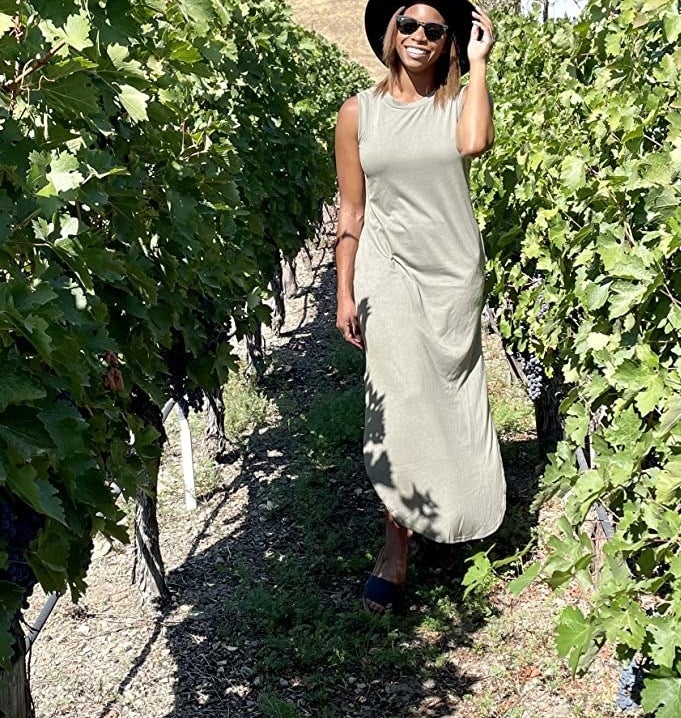Reviewer in vineyard wearing the light green dress with sunhat