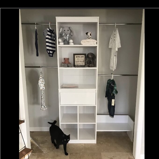 reviewers photo of the closet system with clothes hanging