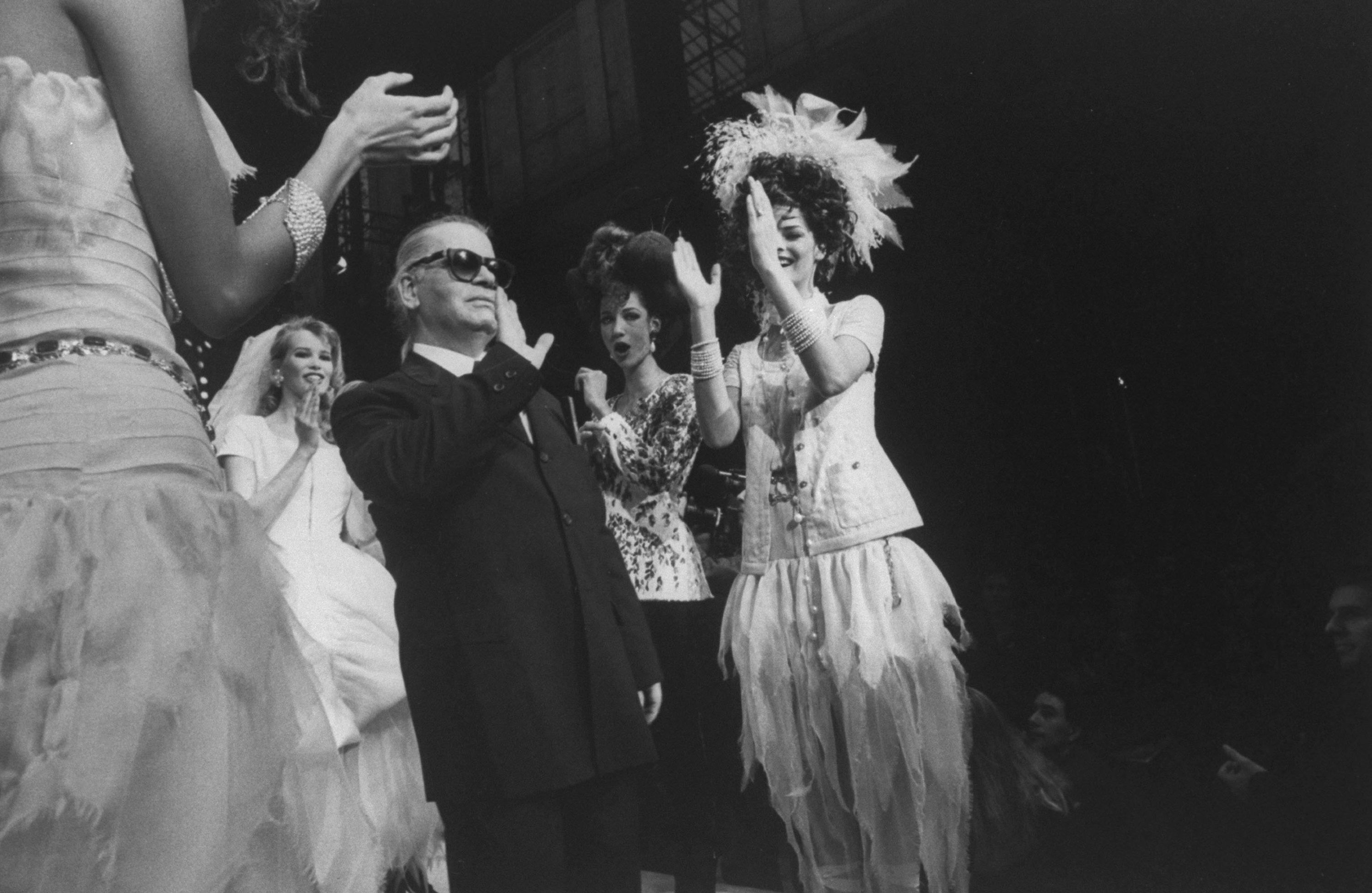 Karl waving to the crowd after a runway show