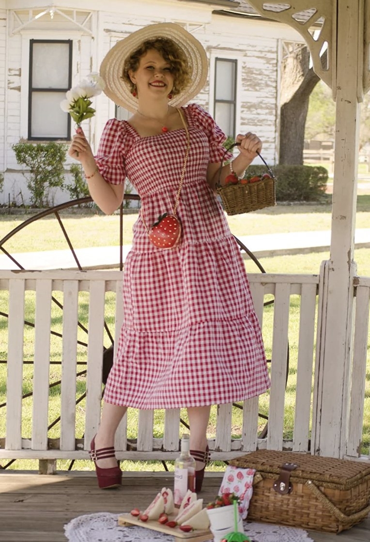 A reviewer wearing the dress in white and red plaid