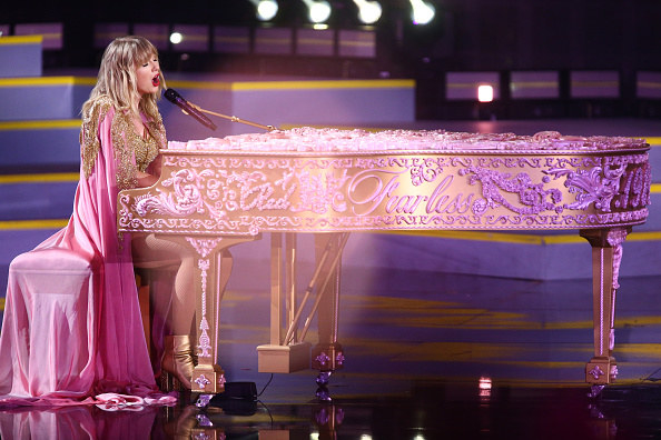 Taylor Swift playing piano while singing