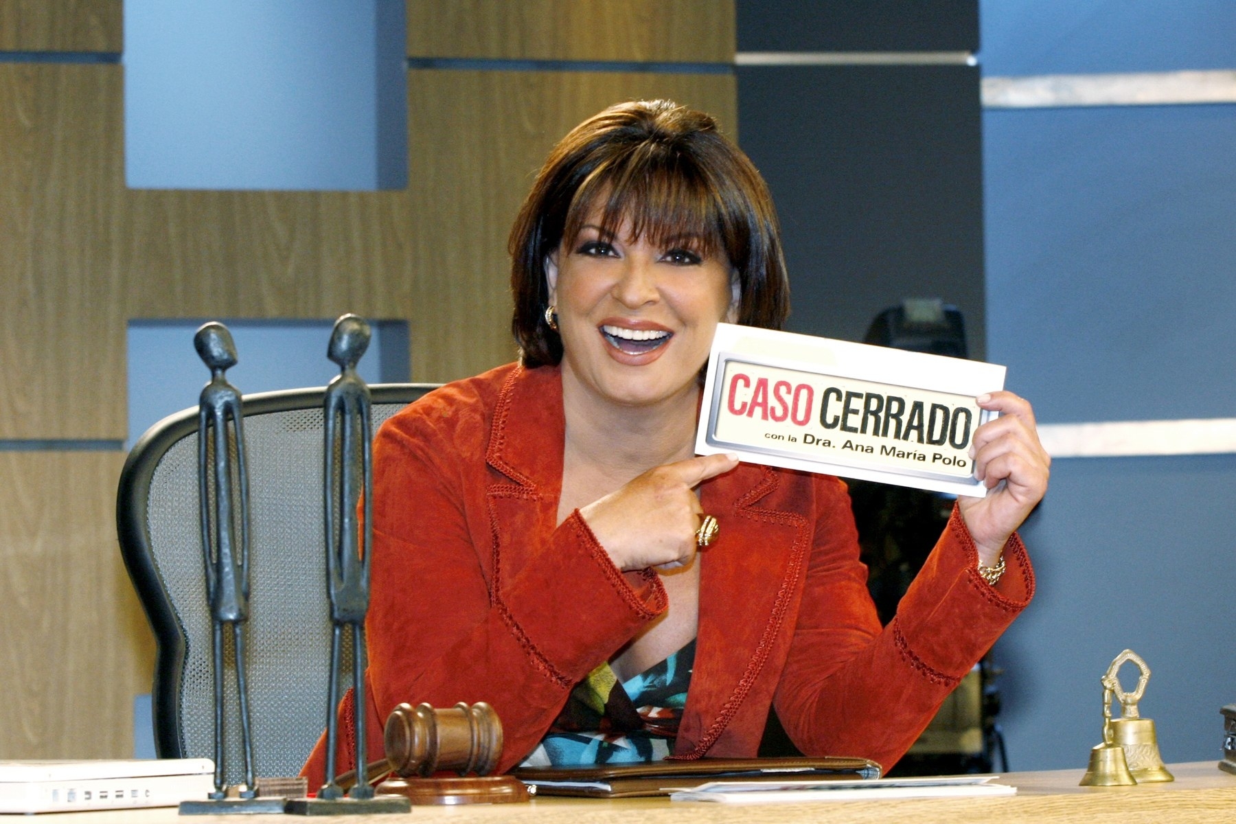 Doctora Ana Maria Polo pointing at a sign that reads Caso Cerrado