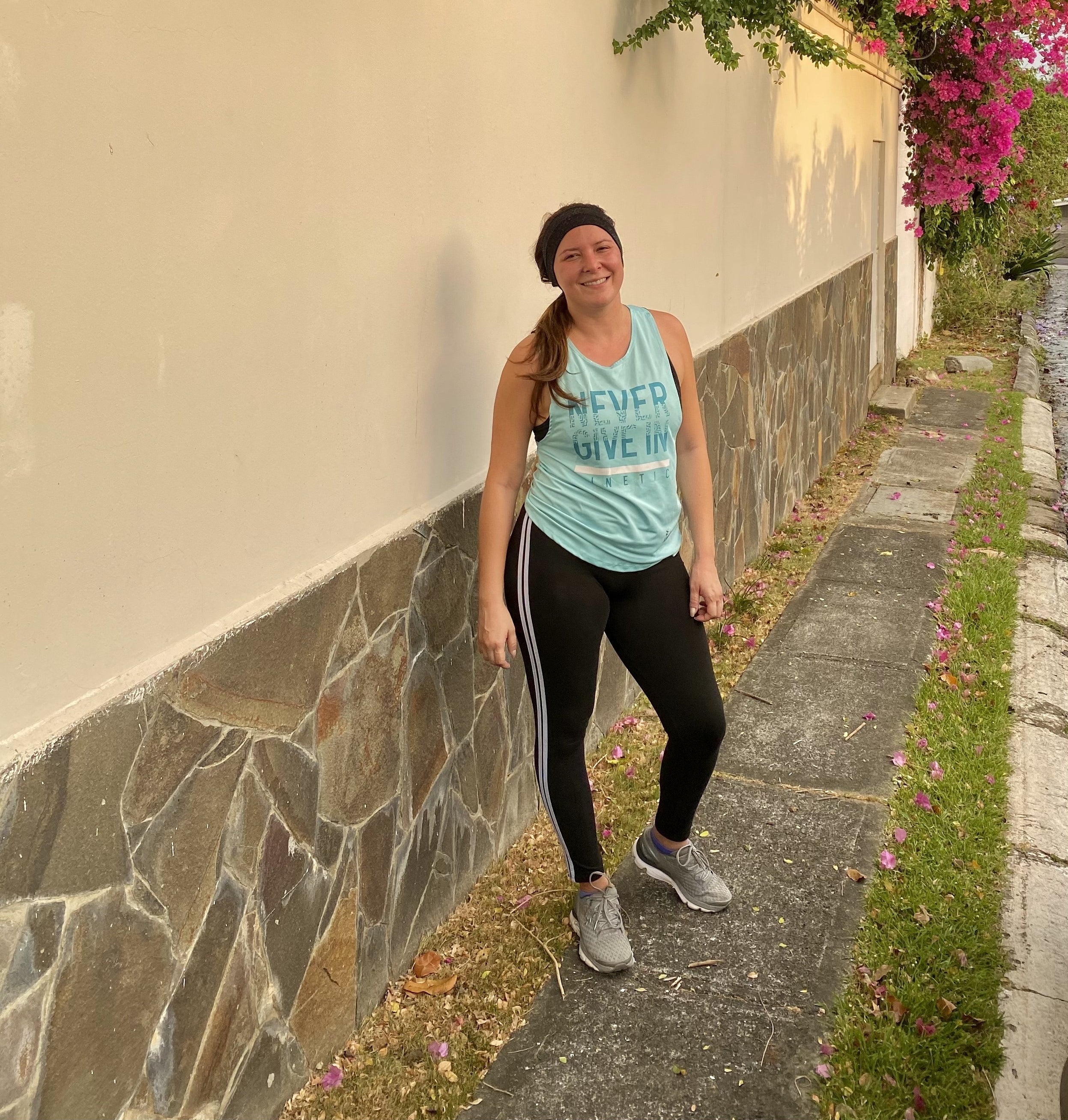 Reviewer standing outside in striped black leggings with workout tank