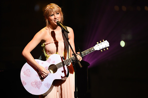 Taylor Swift playing guitar and singing live