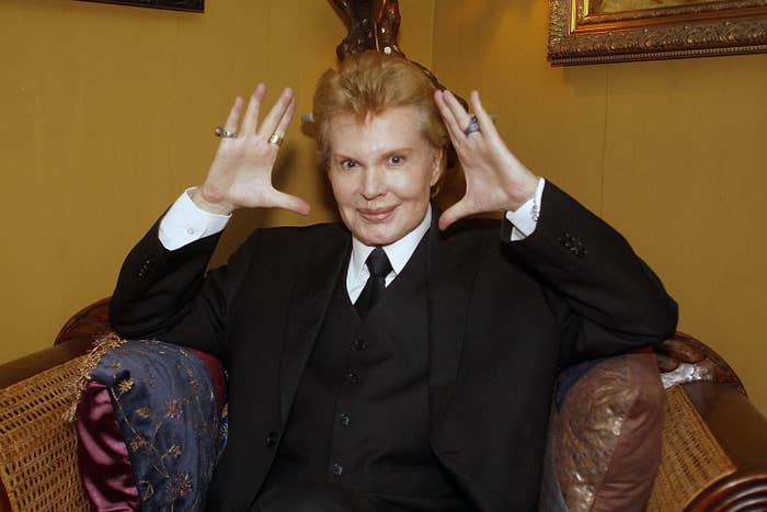 Walter Mercado sitting on a chair posing for a photo