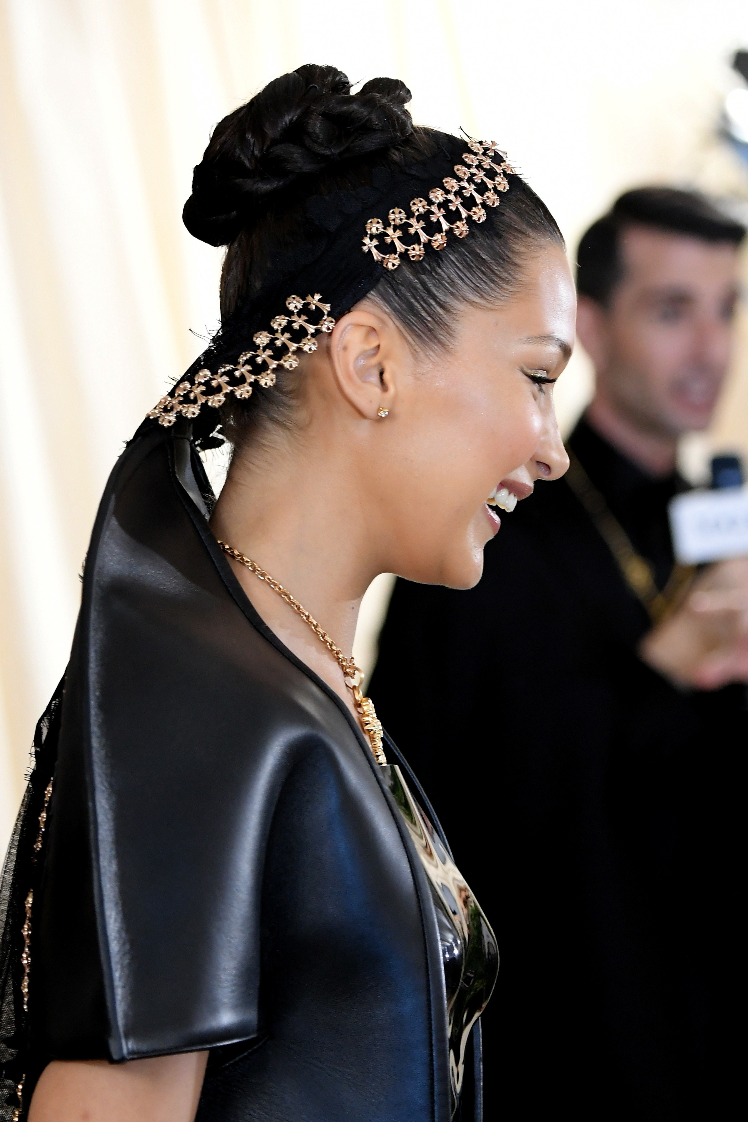Bella Hadid smiling and wearing an ornate, bejeweled headpiece