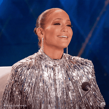 JLo laughing in a glittery dress