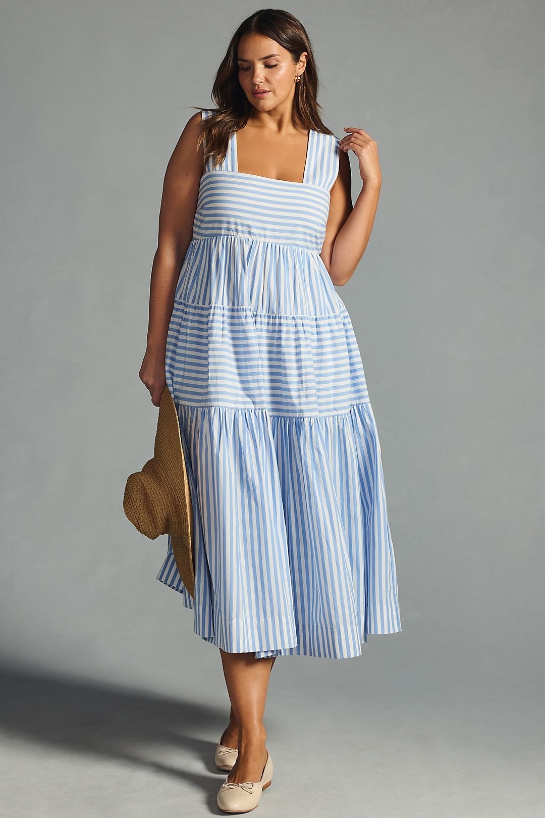 model in white and light blue striped babydoll midi dress with wide tank sleeves