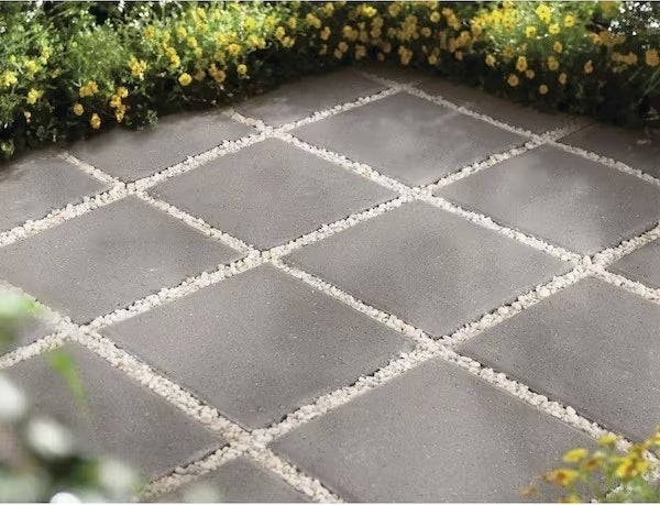 the grey pavers, spaced evenly, the gaps between filled with white rocks