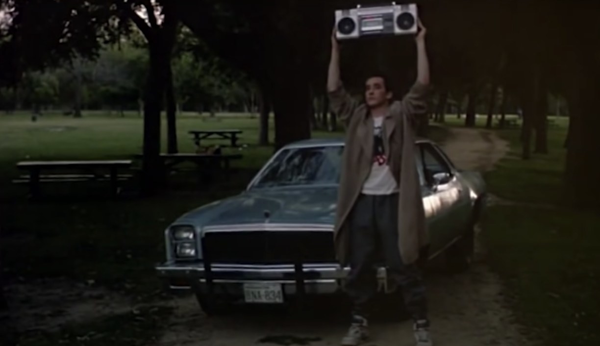 John Cusack holding a boom box above his head in a scene from "Say Anything"