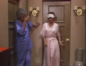 Blanche struts forward in a matching PJ set and eye mask while Dorothy shakes her head (via The Golden Girls)