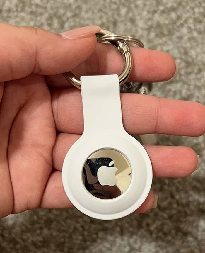 reviewer holding a white airtag keychain