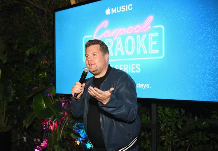James Corden onstage in front of a screen with Carpool Karaoke