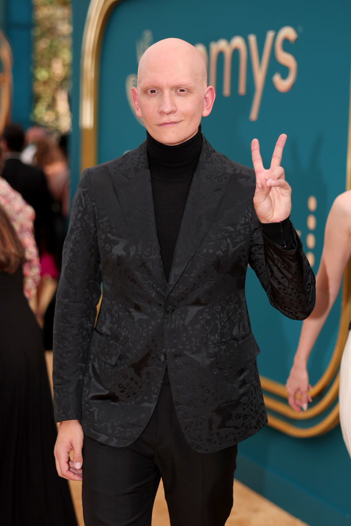 Anthony in a turtleneck giving the peace sign