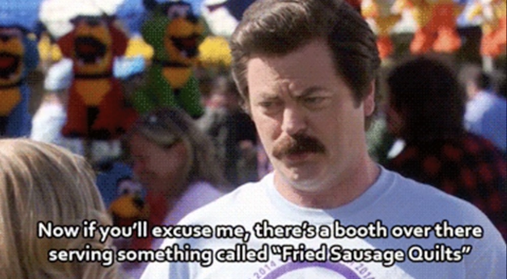 Ron Swanson from Parks and Rec at a fair saying &quot;Now if you&#x27;ll excuse me, there&#x27;s a booth over there serving something called &#x27;Fried Sausage Quilts&#x27;&quot;