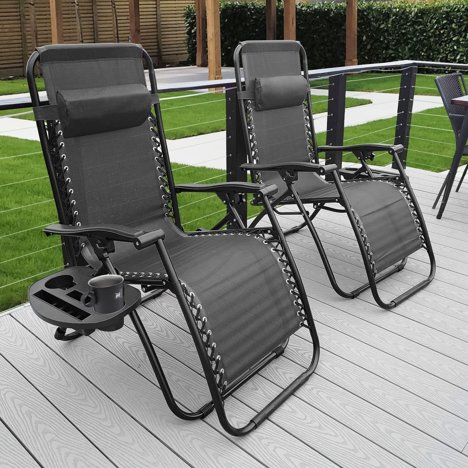 a pair of black lounge chairs on a backyard deck