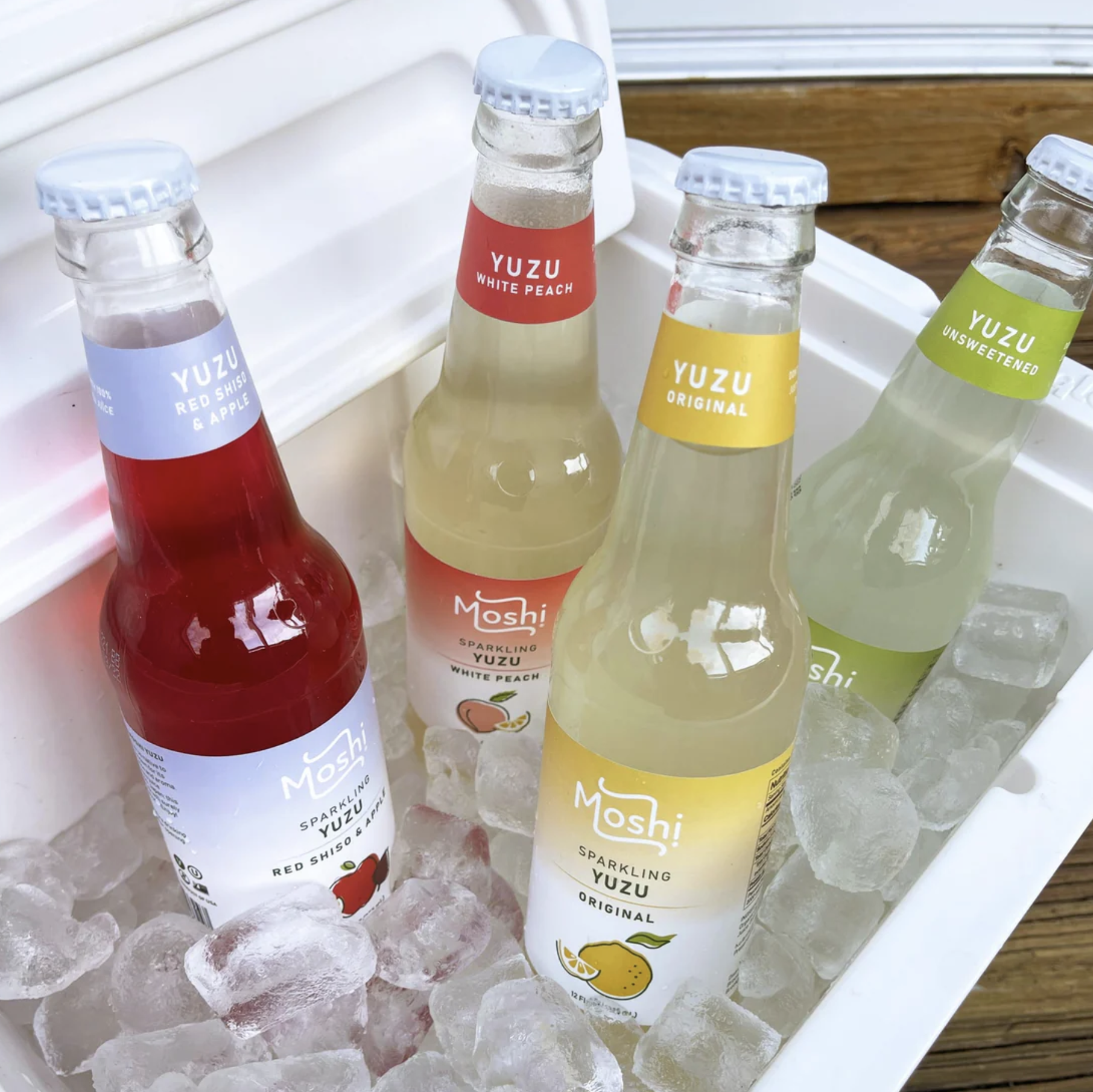 Four bottles of sparkling yuzu in a cooler full of ice.