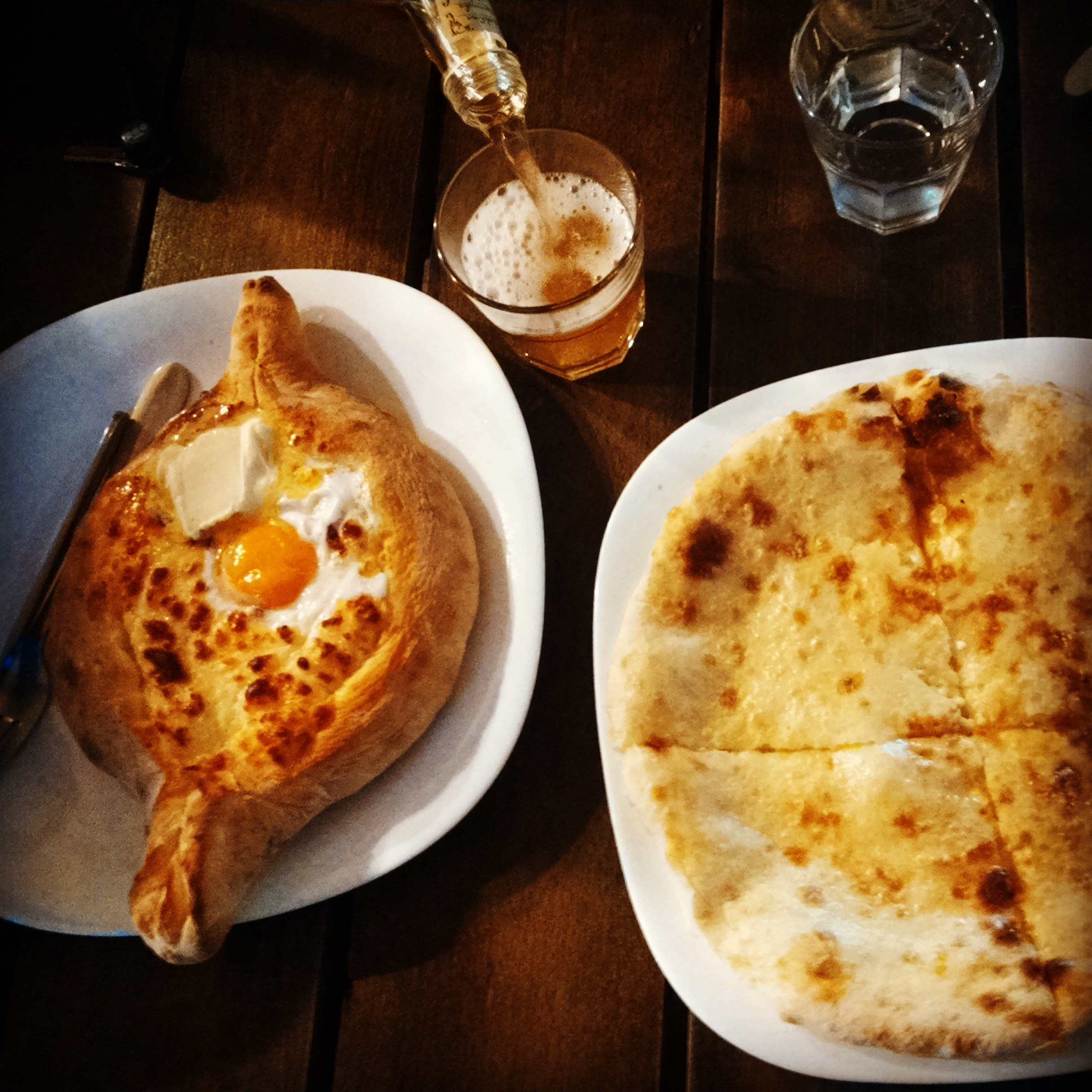 Georgian food, including acharuli khachapuli, on a table