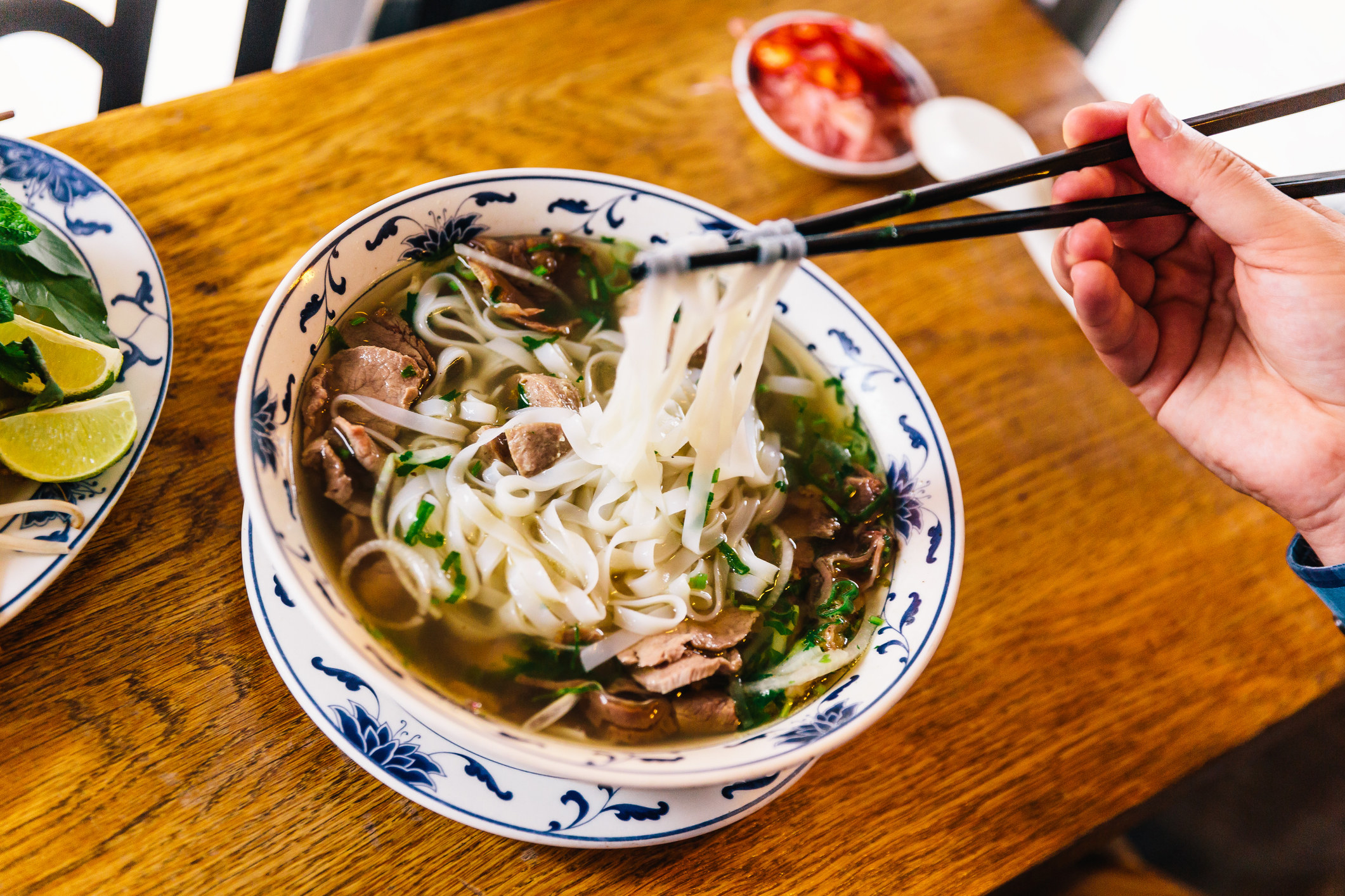 Eating traditional Vietnamese Pho soup in a restaurant