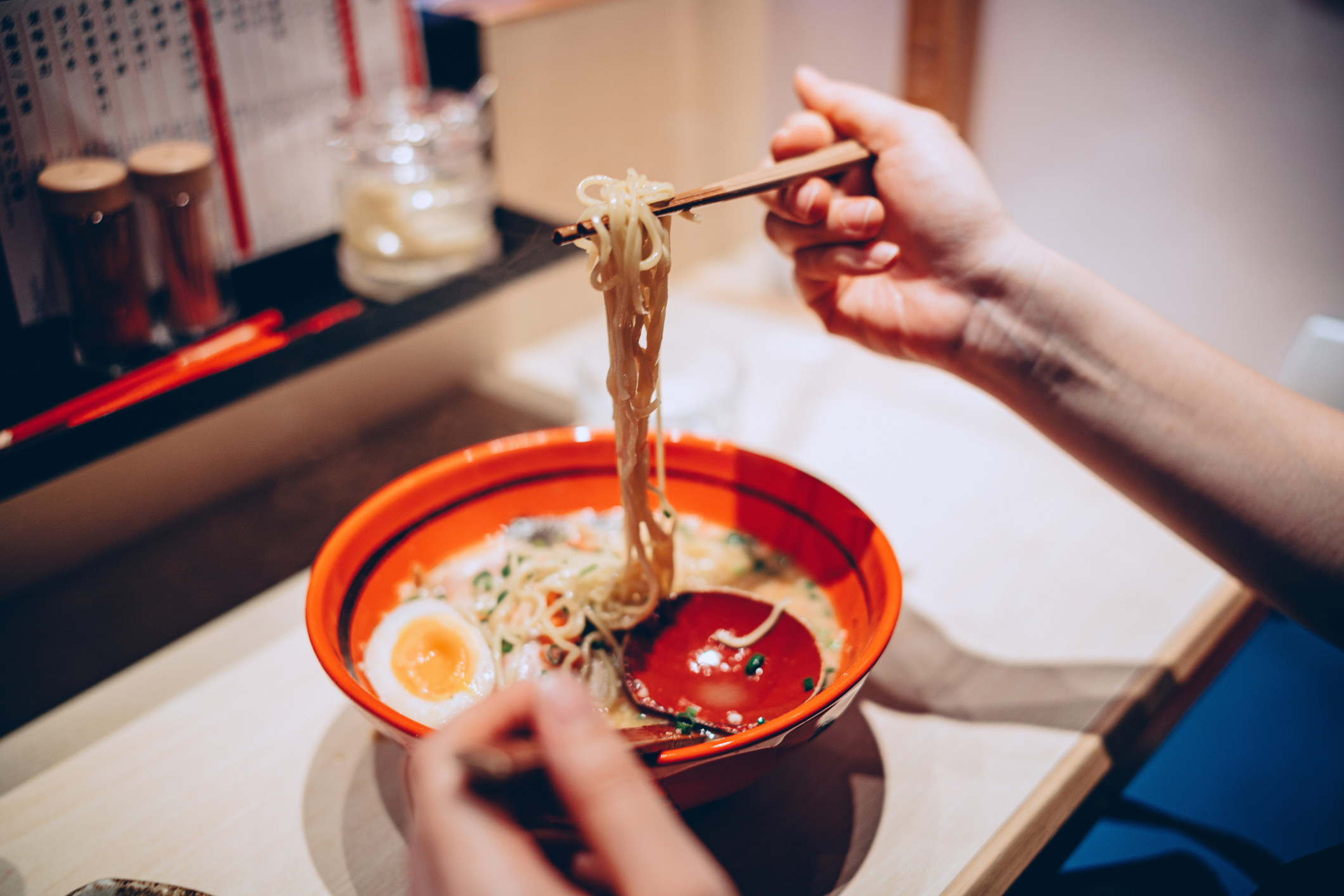 A person eating a bowl of ramen