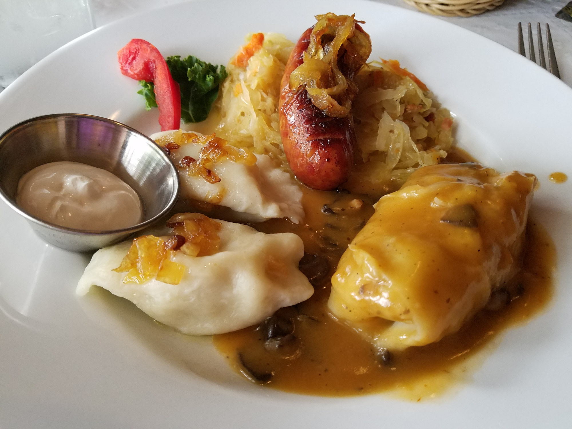 Plate of Polish food including kielbasa, pierogi, and cabbage