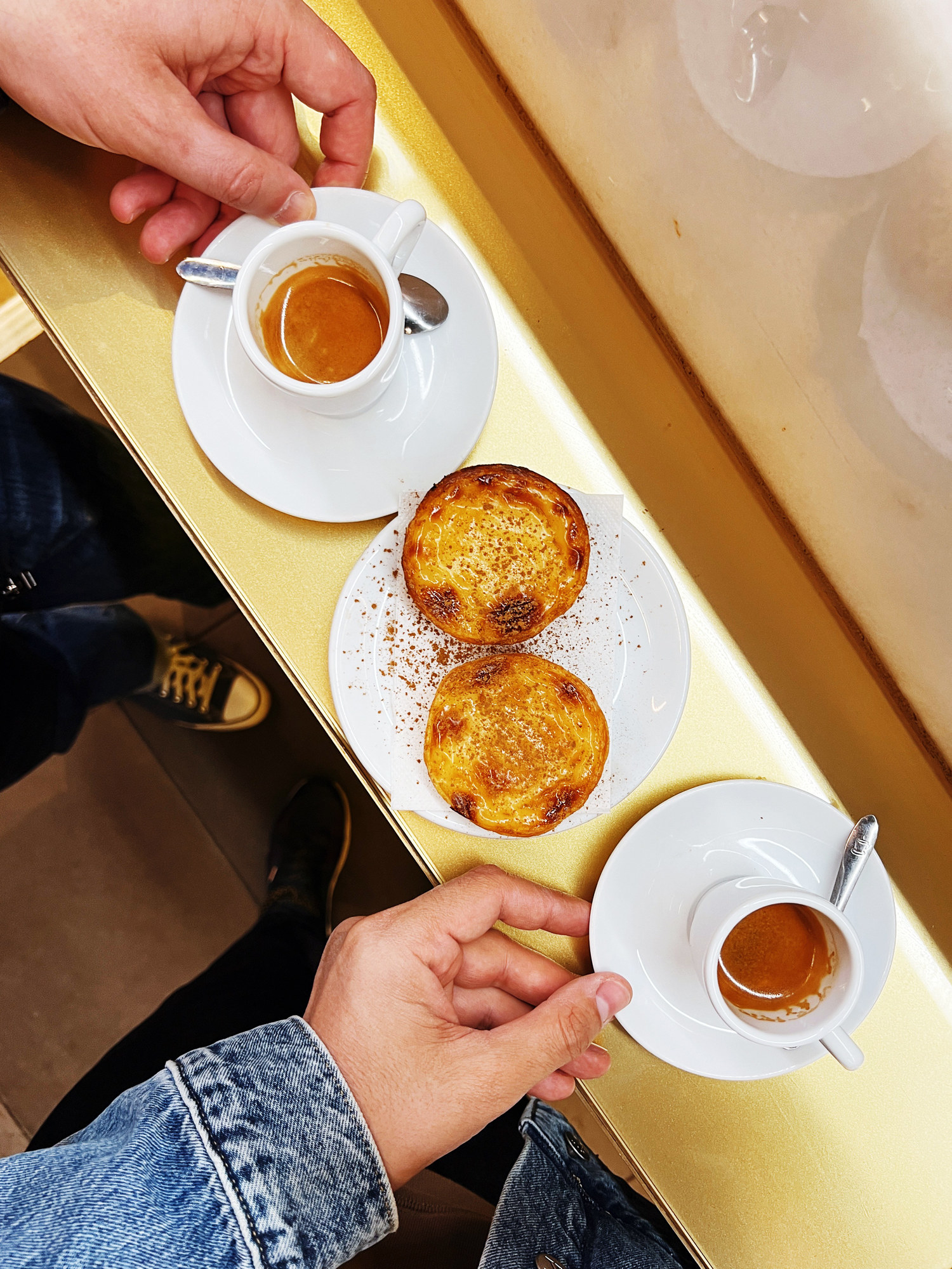 Eating pastel de nata pastry with espresso coffee at a bakery in Lisbon