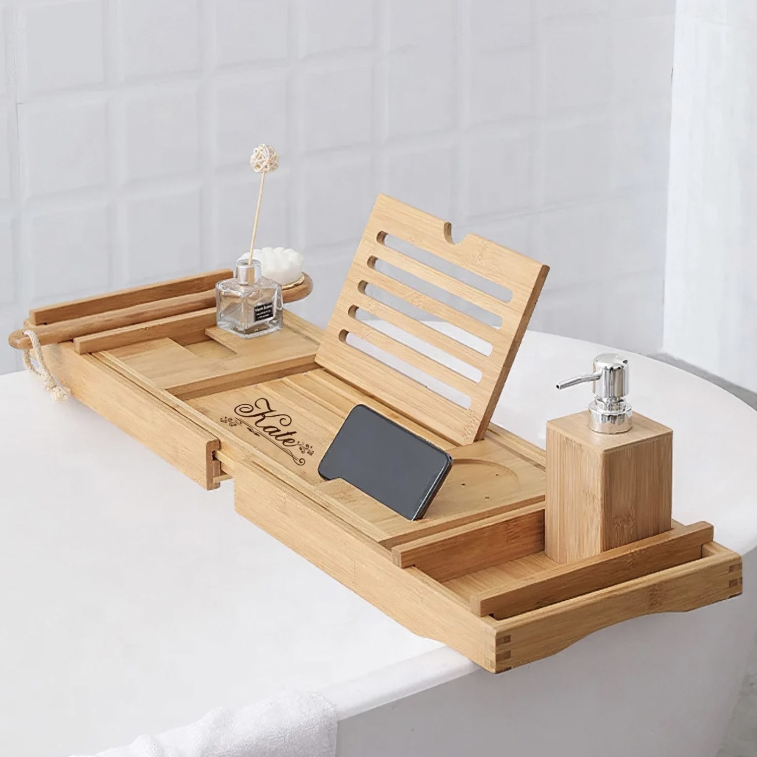 The tray on tub engraved with Kate and holding phone, brushes, and soap