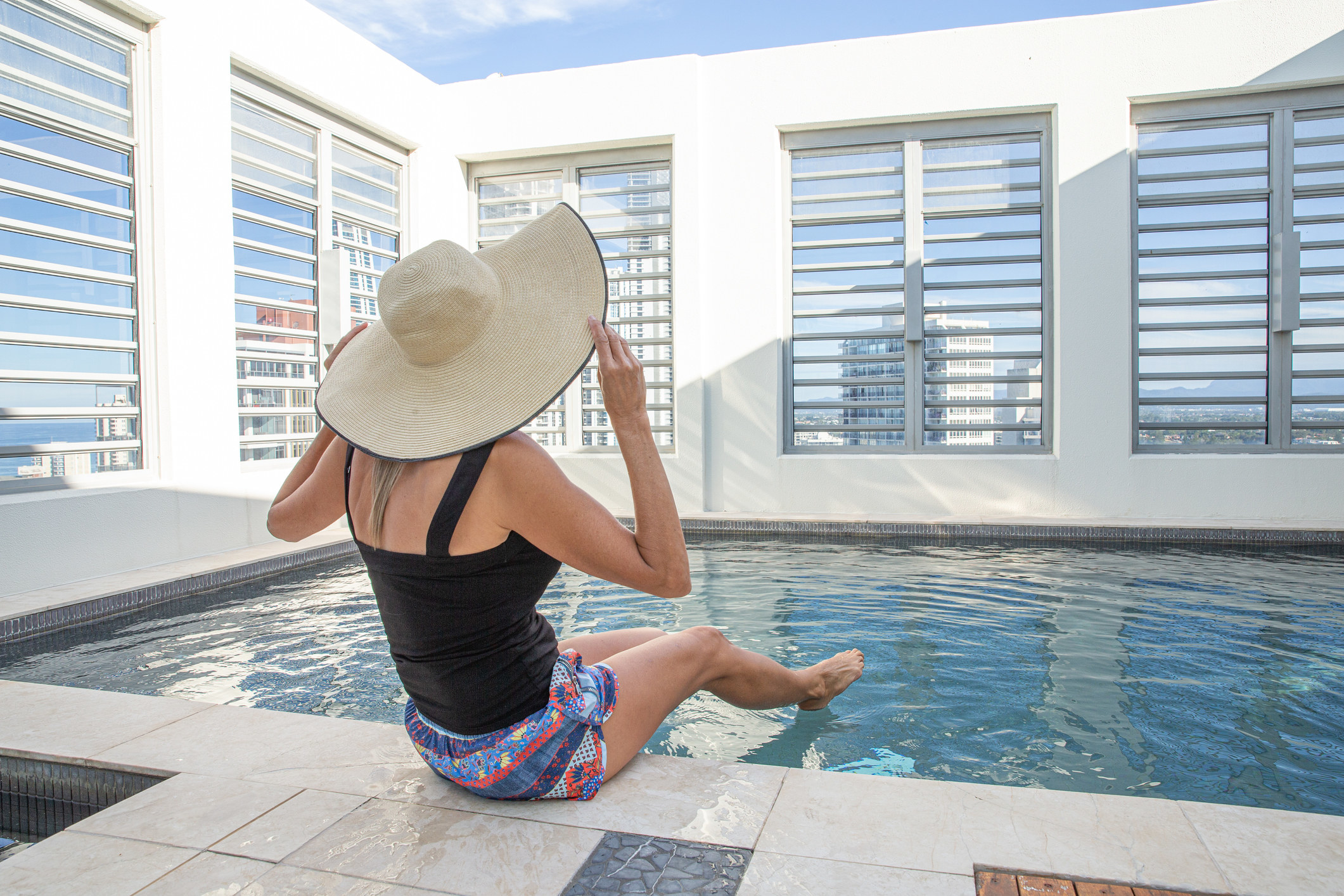 A person sitting on the side of an indoor pool