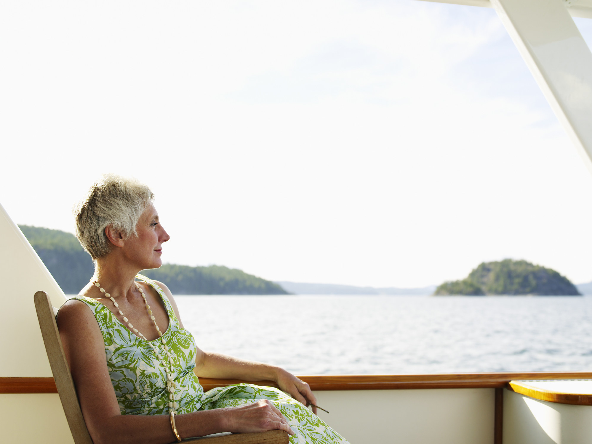 An older woman sitting on the deck of a ship