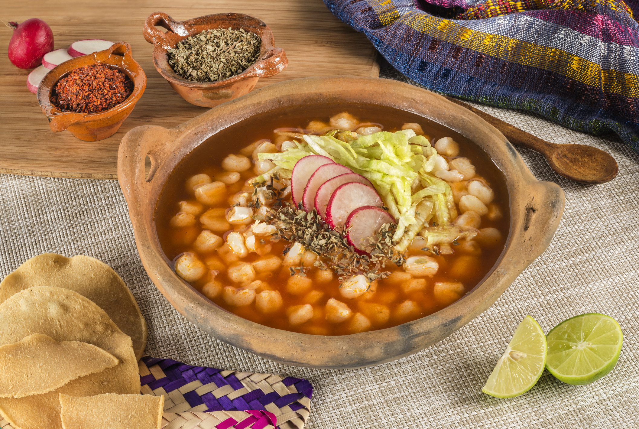 A bowl of pozole with beans and radishes