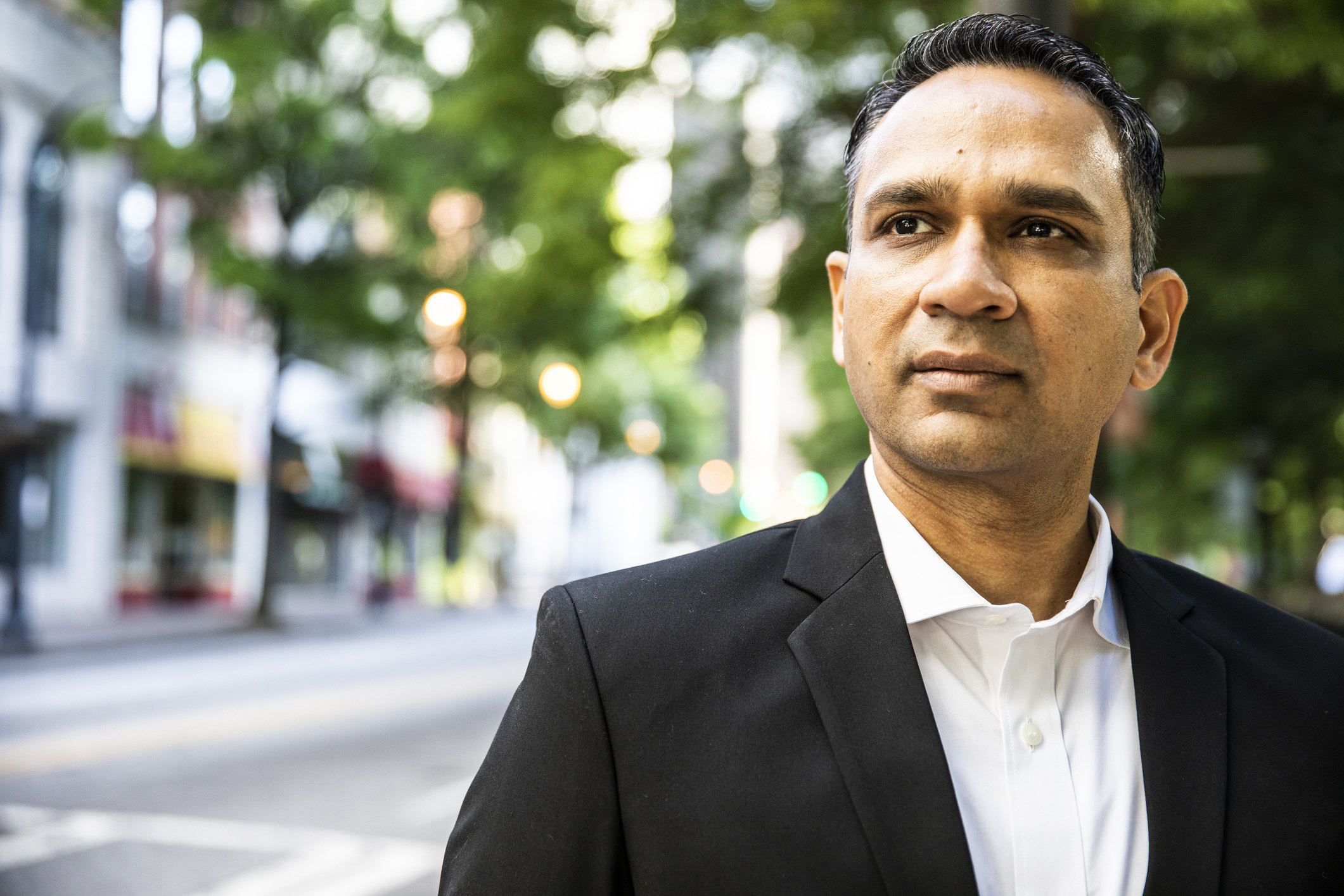 Close-up of a man in a suit jacket standing on a street