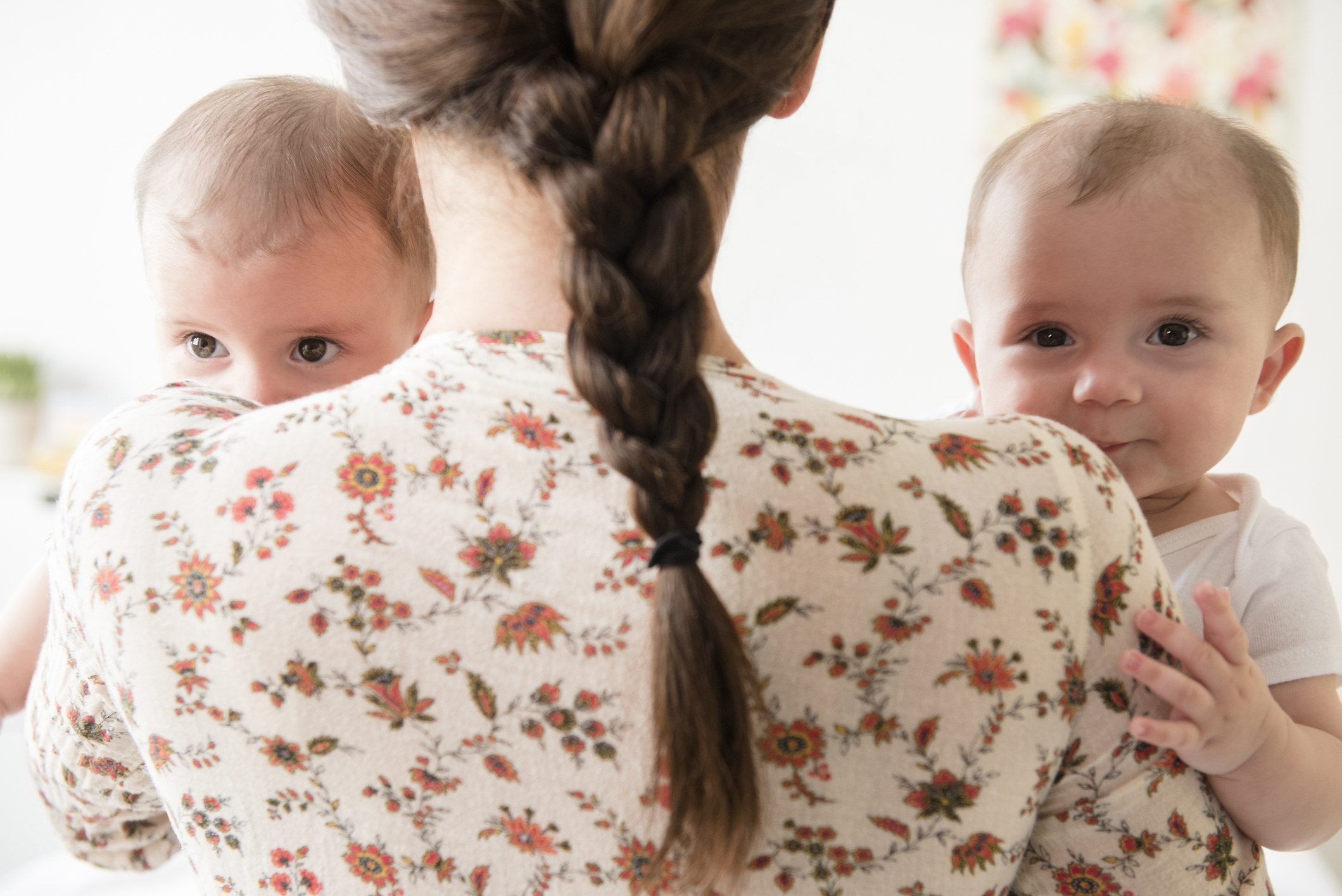 A woman holding two babies