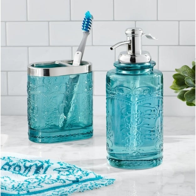 The teal bathroom accessory kit on the counter